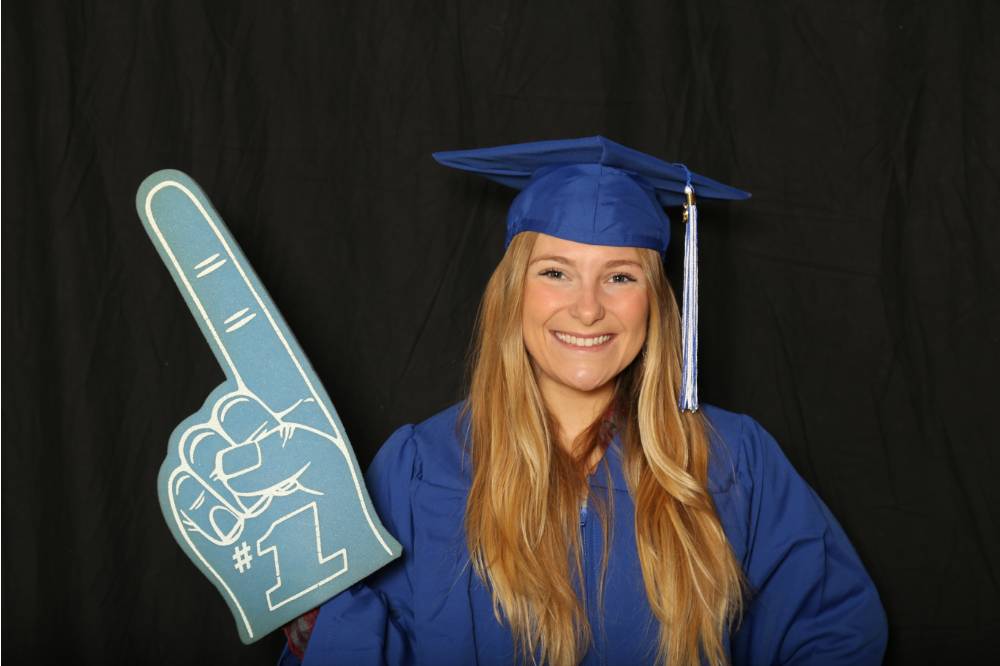 student at photobooth with foam finger